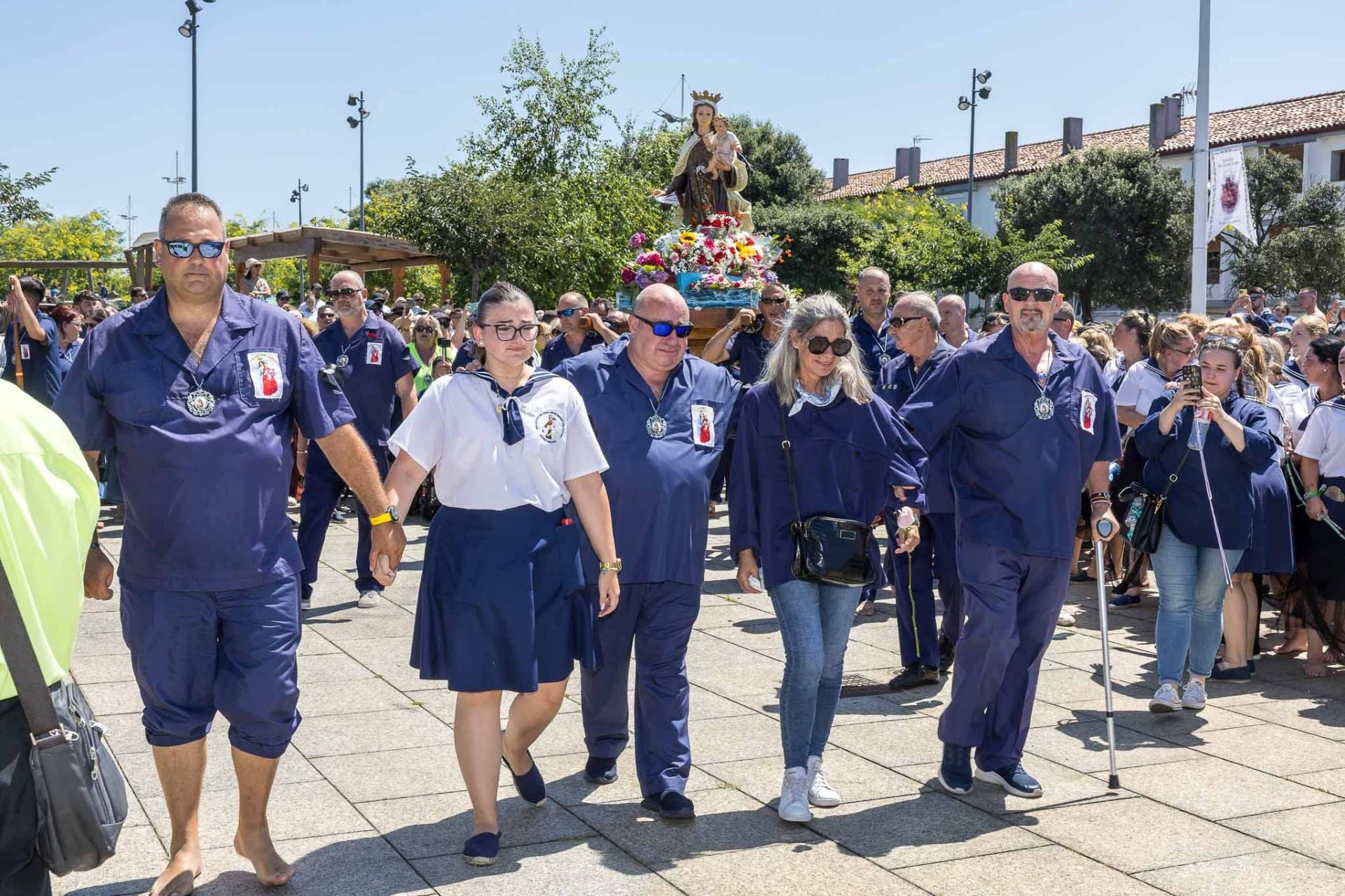 Varios vecinos que han perdido familiares, a su llegada al final de la procesión, que este año no embarcó para realizar la procesión marítima. 