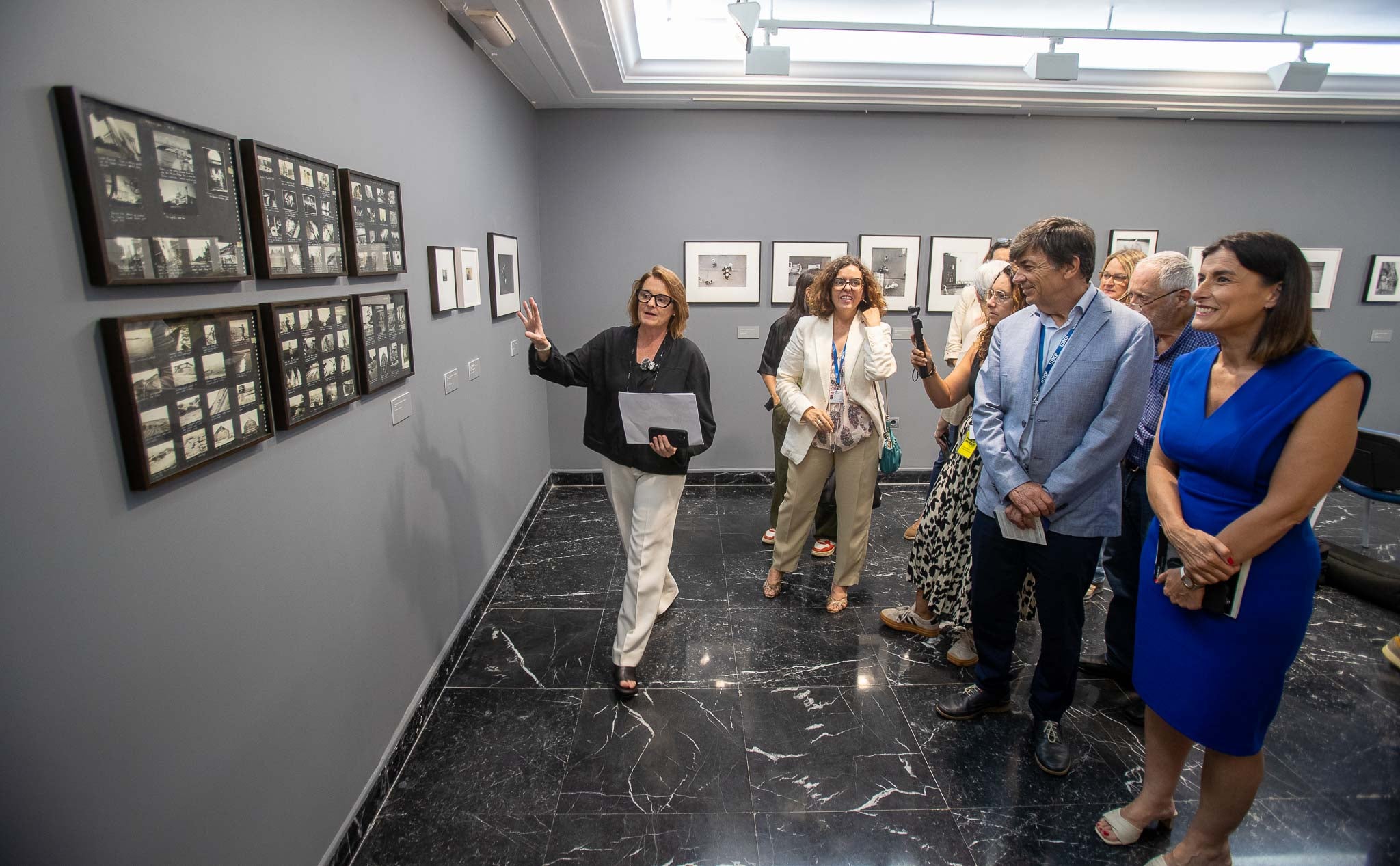 La comisaria de la exposición Anne Morine guió por la exposición a la alcaldesa Gema Igual y al rector de la UIMP Carlos Andradas y les explicó detalles de cada imagen.