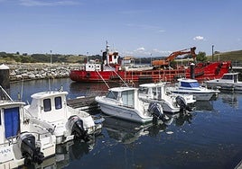 La draga trabaja en el interior del abrigo del puerto de Suances.