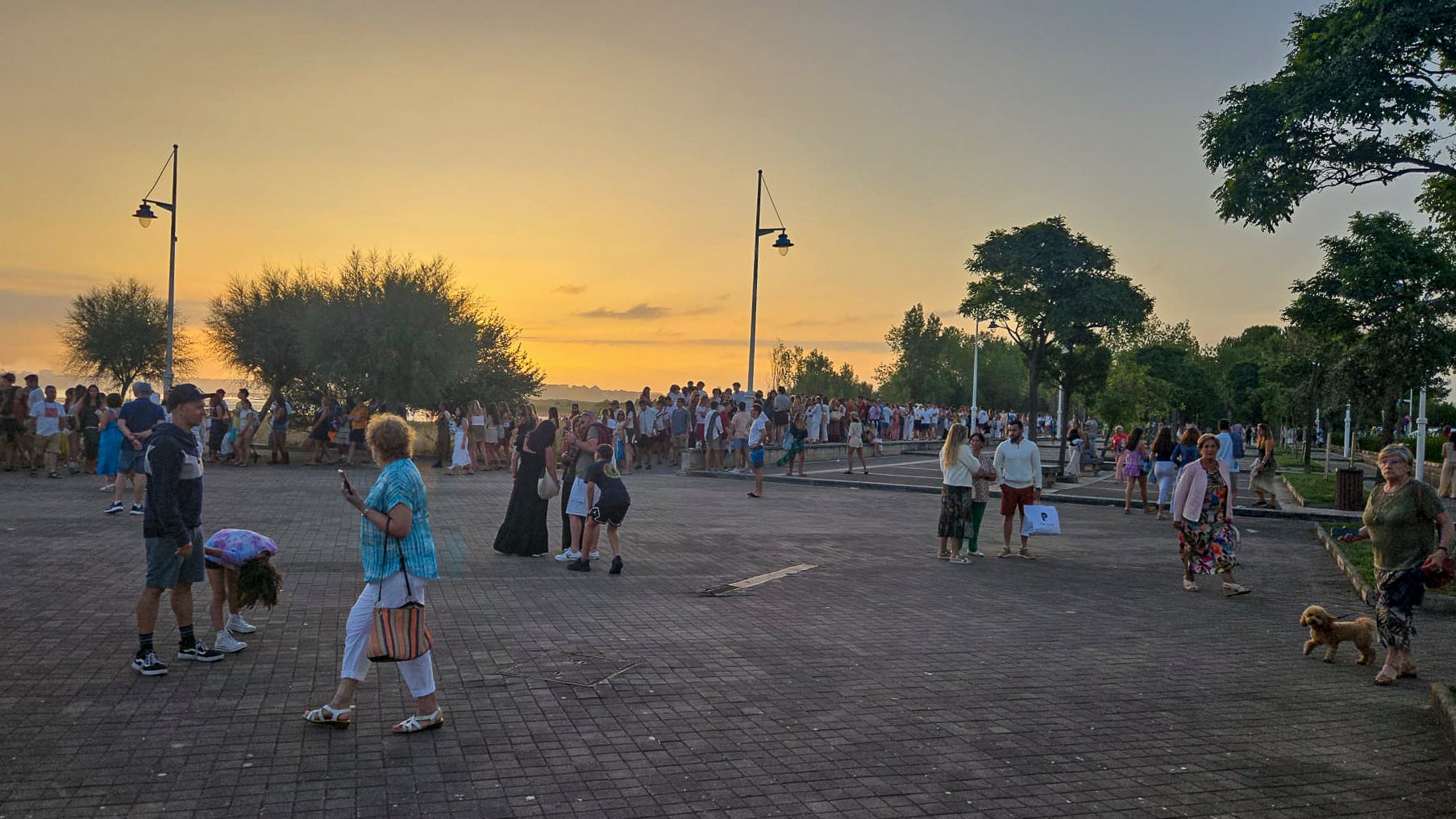 Multitud de personas esperan en el muelle de Somo a la lancha para volver a Santander.