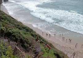 Los efectivos atienden al parapentista que se ha precipitado en la playa de Gerra.