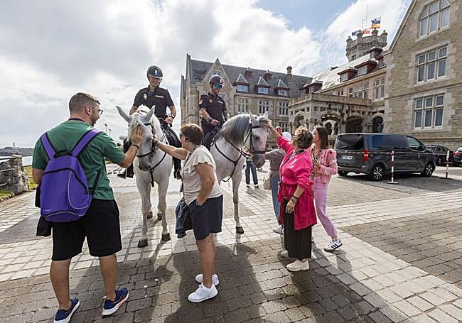 Un grupo de ciudadanos saluda a los agentes y acaricia a los caballos