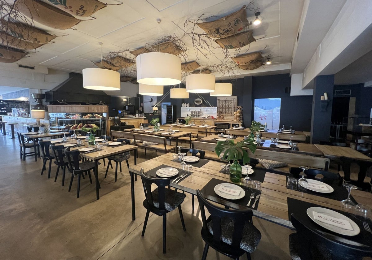 Comedor principal de la taberna, con la parrilla a la vista del cliente, así como el expositor con los chuleteros.
