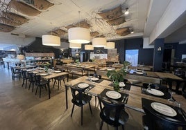 Comedor principal de la taberna, con la parrilla a la vista del cliente, así como el expositor con los chuleteros.