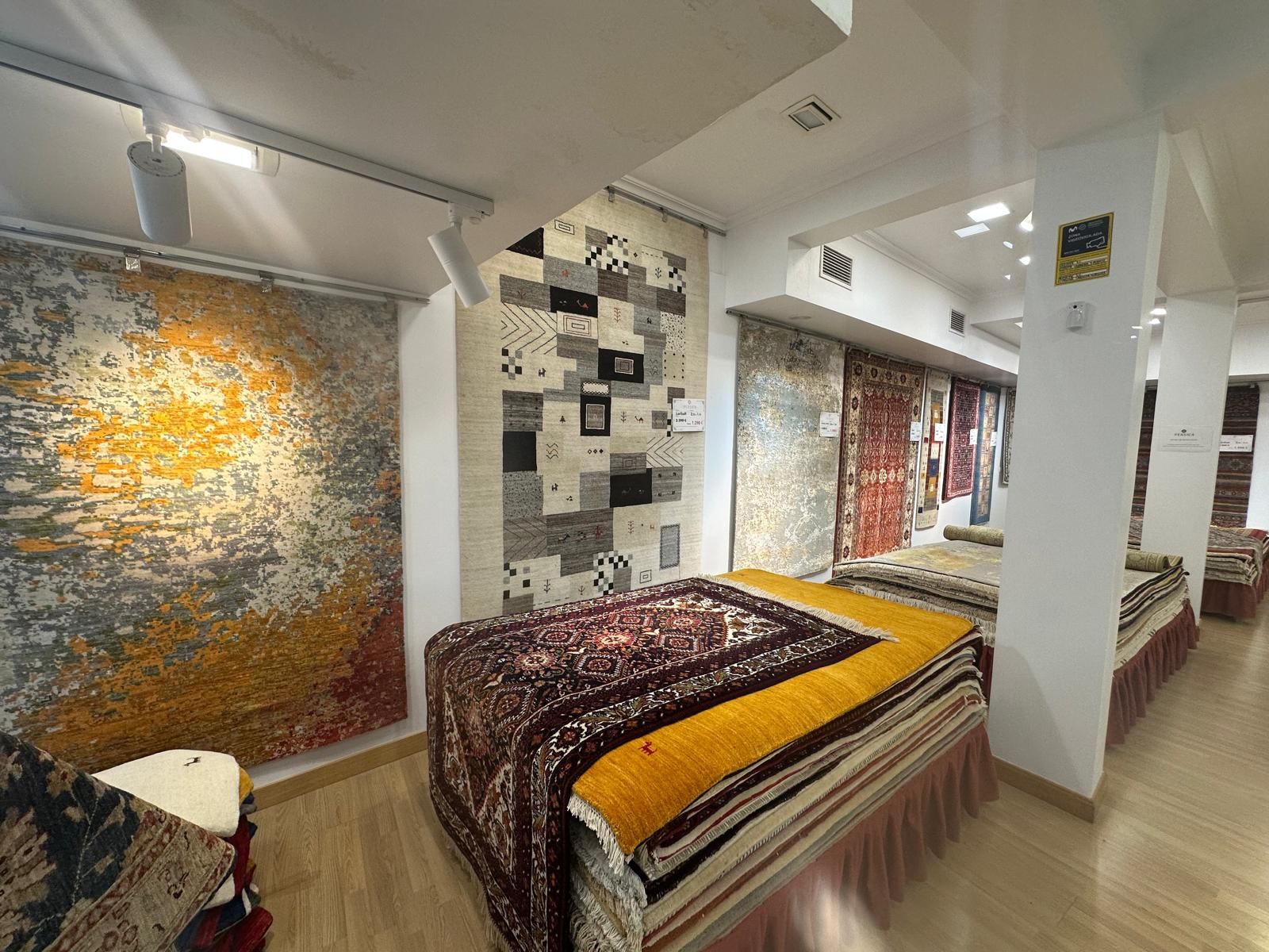 Interior de la tienda Pérsica en Santander, donde se puede apreciar la amplia y colorida selección de alfombras y kilims artesanales.