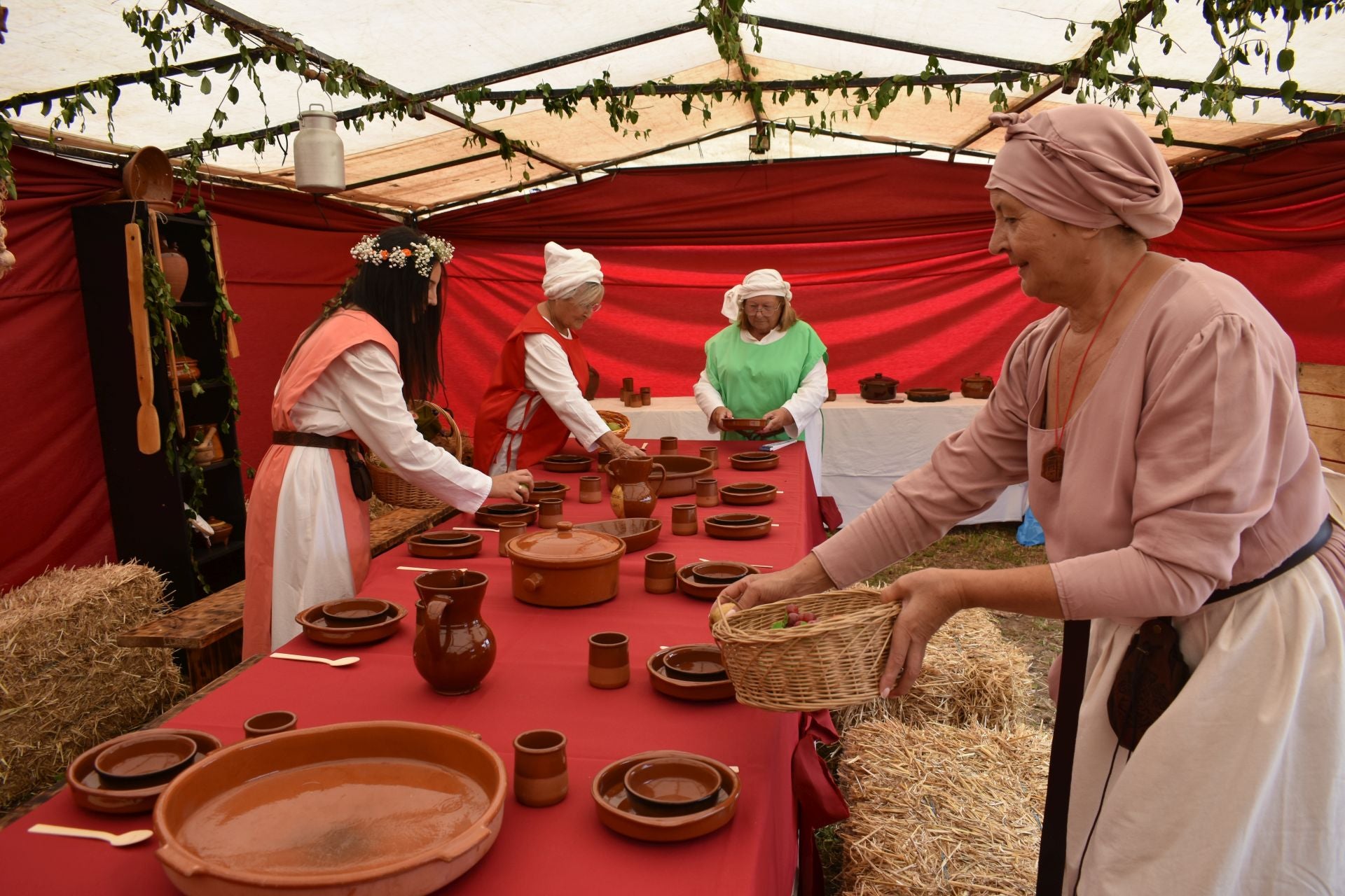 Los participantes en la fiesta preparan la mesa para la comida común.