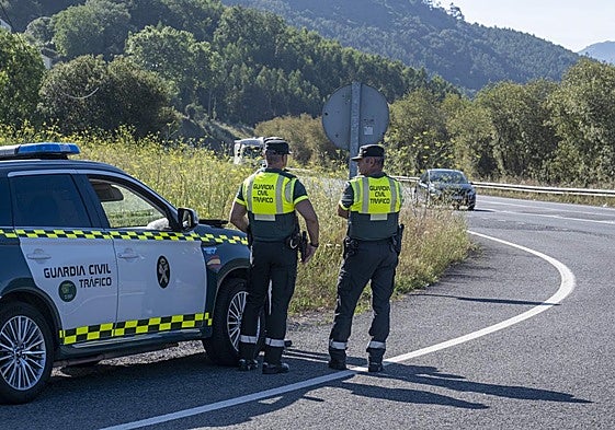 Pareja de agentes de la Agrupación de Tráfico de la Guardia Civil, en una carretera de Cantabria.