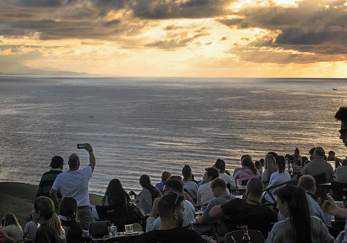 Las numerosas personas congregadas en El Rayo Verde contemplan con expectación el momento de la puesta del sol.