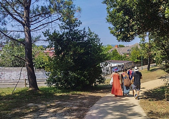 Bañistas atraviesan la senda del Monte Arna de camino a la playa de Somo.