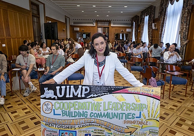 Blanco, en el Aula Blas Cabrera, con uno de los paneles realizados por la ilustradora Delaney Cox.