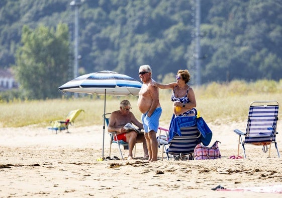 Una mujer da crema protectar solar a un hombre esta mañana en Cantabria.