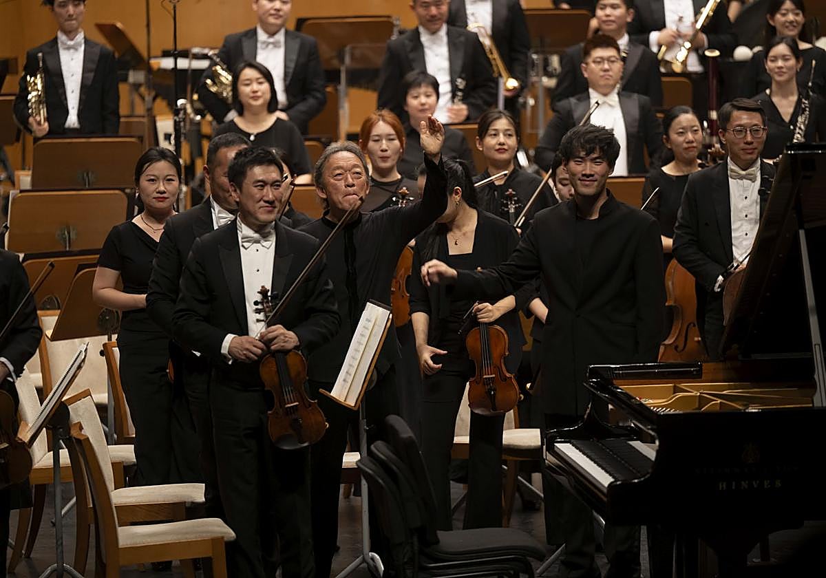La formación orquestal china con el maestro Myung–Whun Chung y el pianista Bruce Liu, en el centro.