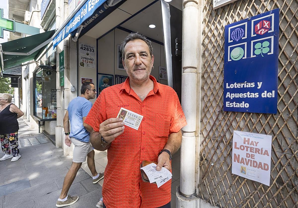Un comprador de Lotería de Navidad posa con su décimo, ayer, en la administración 'La Anjana' de la calle Calvo Sotelo.