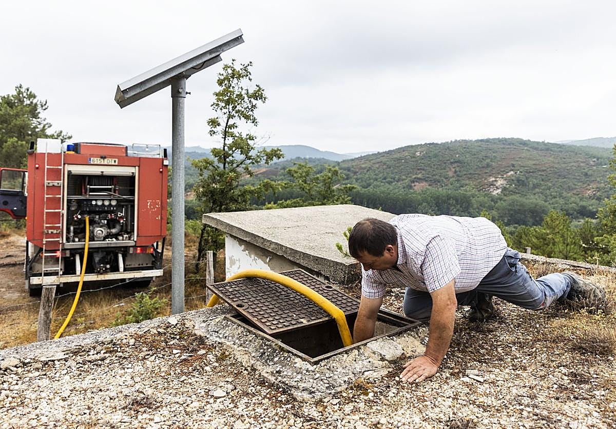 El operario de un camión cisterna abastece de agua a un depósito de Valderredible.