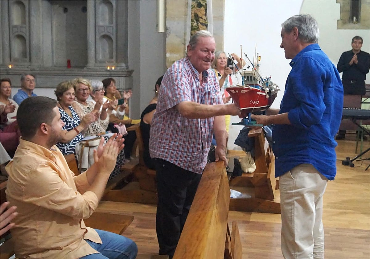 El homenajeado recibe un obsequio de manos del alcalde de Suances.