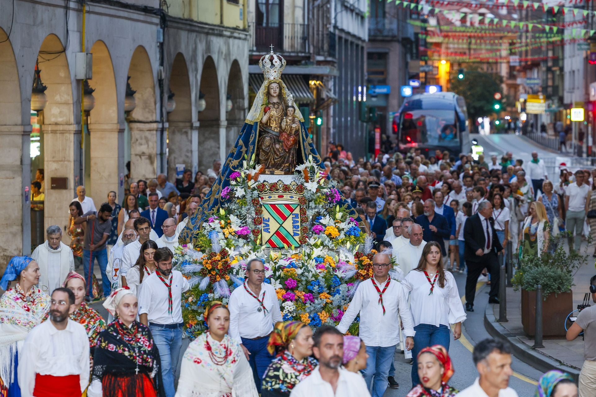 La figura de la Virgen Grande, engalanada con flores y acompañada de sus fieles.