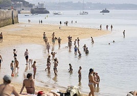 Cántabros y visitantes combaten el calor de esta semana en la orilla de la playa.