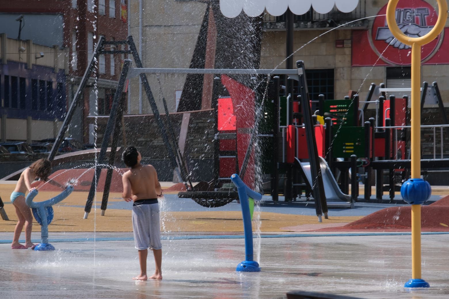 Niños jugando con el agua en el Parque de La Llama de Torrelavega este viernes por la mañana