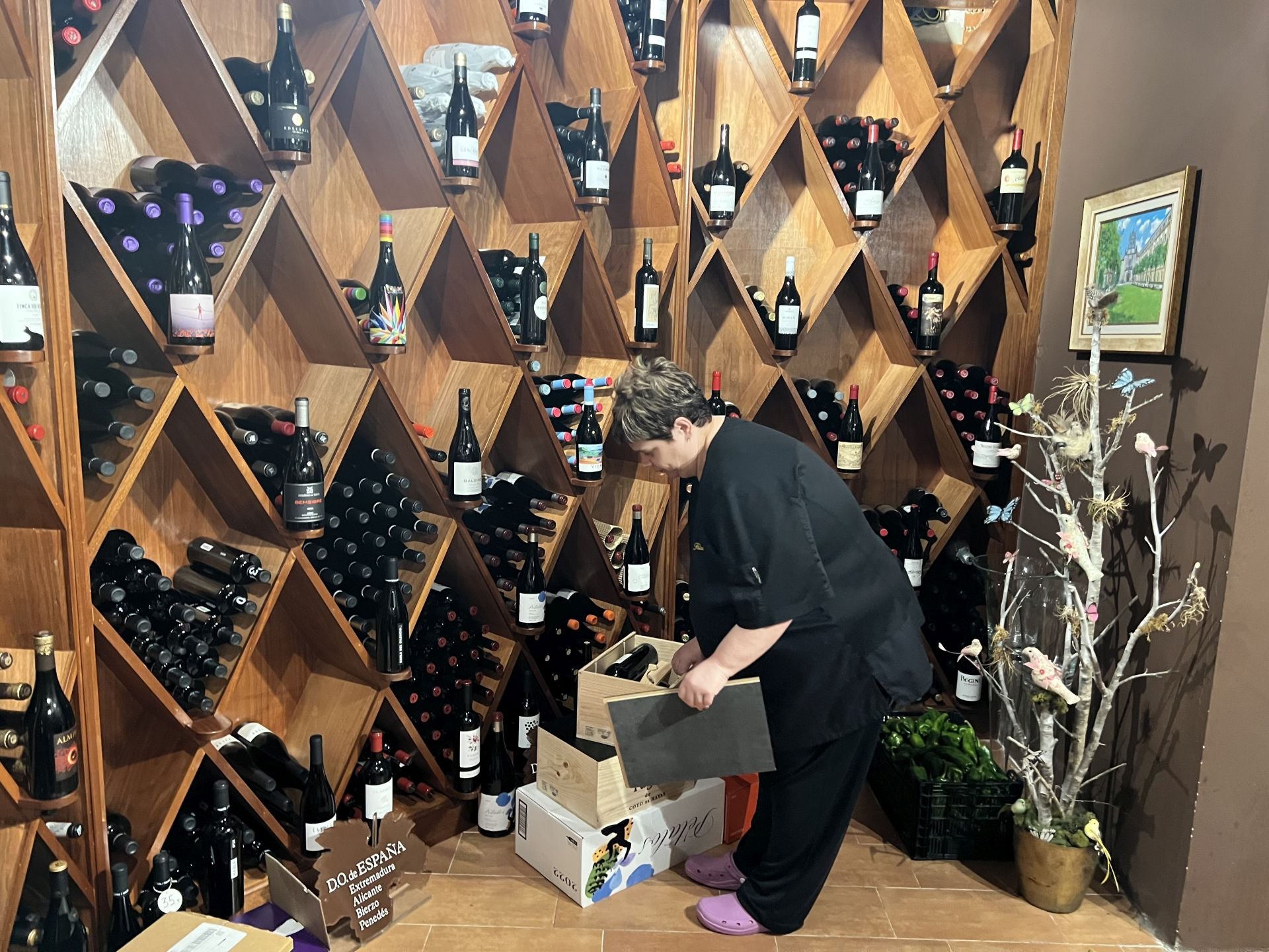 Inma Solana, en la bodega, observa y coloca nuevos vinos que llegaron ayer. La rotación es grande aunque en la bodega hay cerca de un millar de referencias, ordenadas por zonas de origen del vino, y unas diez mil botellas. La temperatura de la bodega es de 14º y la humedad del 70%.
