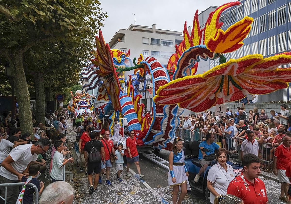 La carroza ganadora del certamen, 'Pandora', avanza durante el desfile, en una abarrotada Avenida de España.