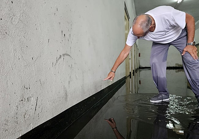 Un propietario señala la marca de hasta dónde llegaba la inundación.