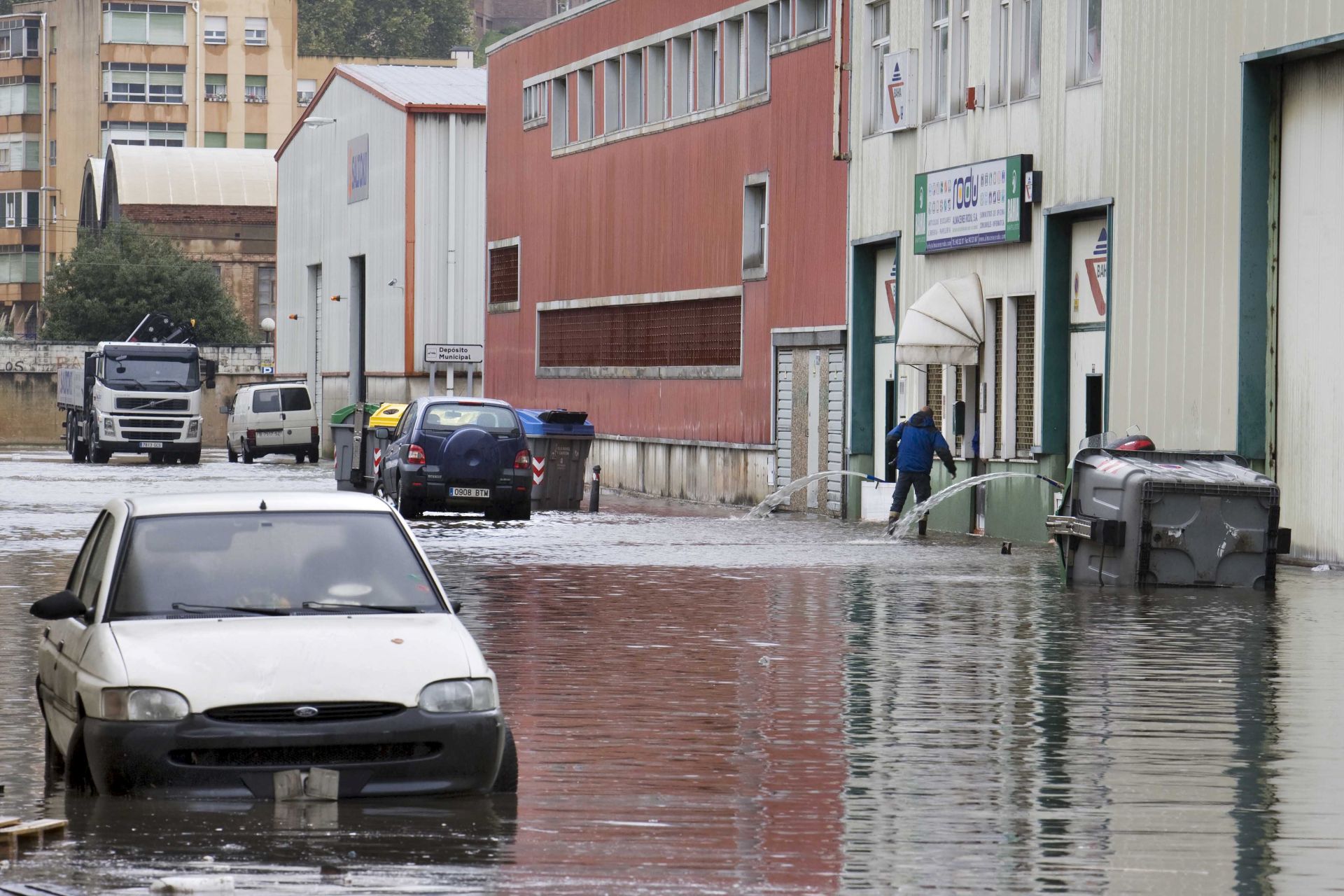Achicando agua con una chupona en el polígono de Candina durante la inundación en 2008