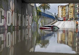 Un coche bajo el agua en el túnel de las vías de Maliaño.