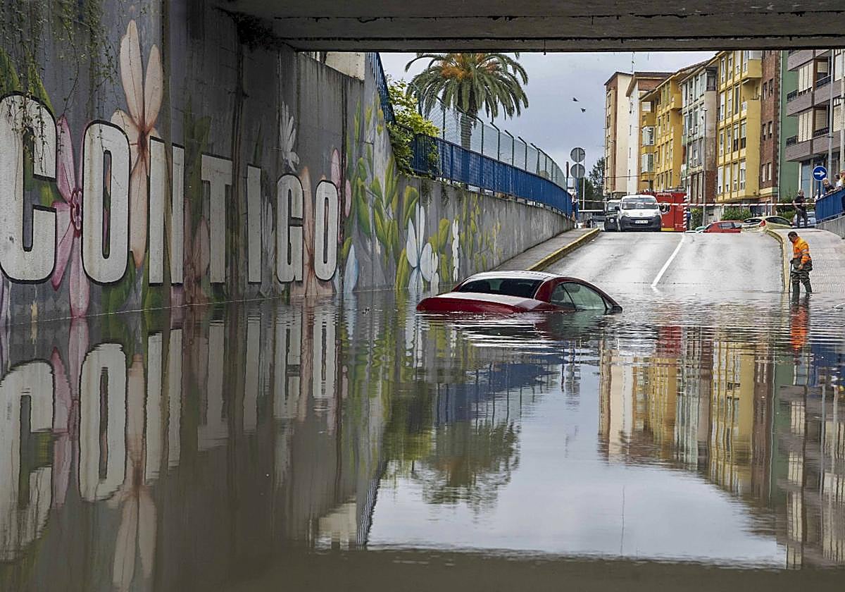 Un coche bajo el agua en el túnel de las vías de Maliaño.