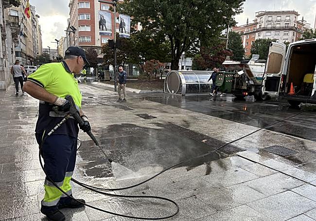 Ramón Terán, poco después de la lluvia, trata de limpiar la plaza del Ayuntamiento.
