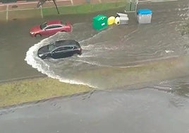 Inundación en la calle principal de El Alisal, con el agua tapando hasta las aceras.