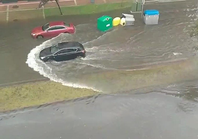 Inundación en la calle principal de El Alisal, con el agua tapando hasta las aceras.