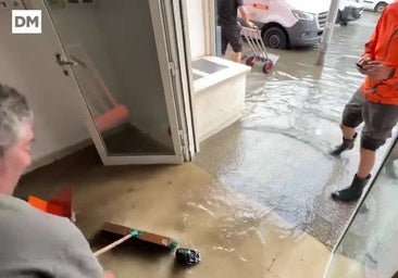 Ciudadanos achicando agua de las oficinas inundadas en Candina