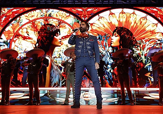 Alejandro Fernández actuando, junto a los mariachis, entre un océano de colores vibrantes