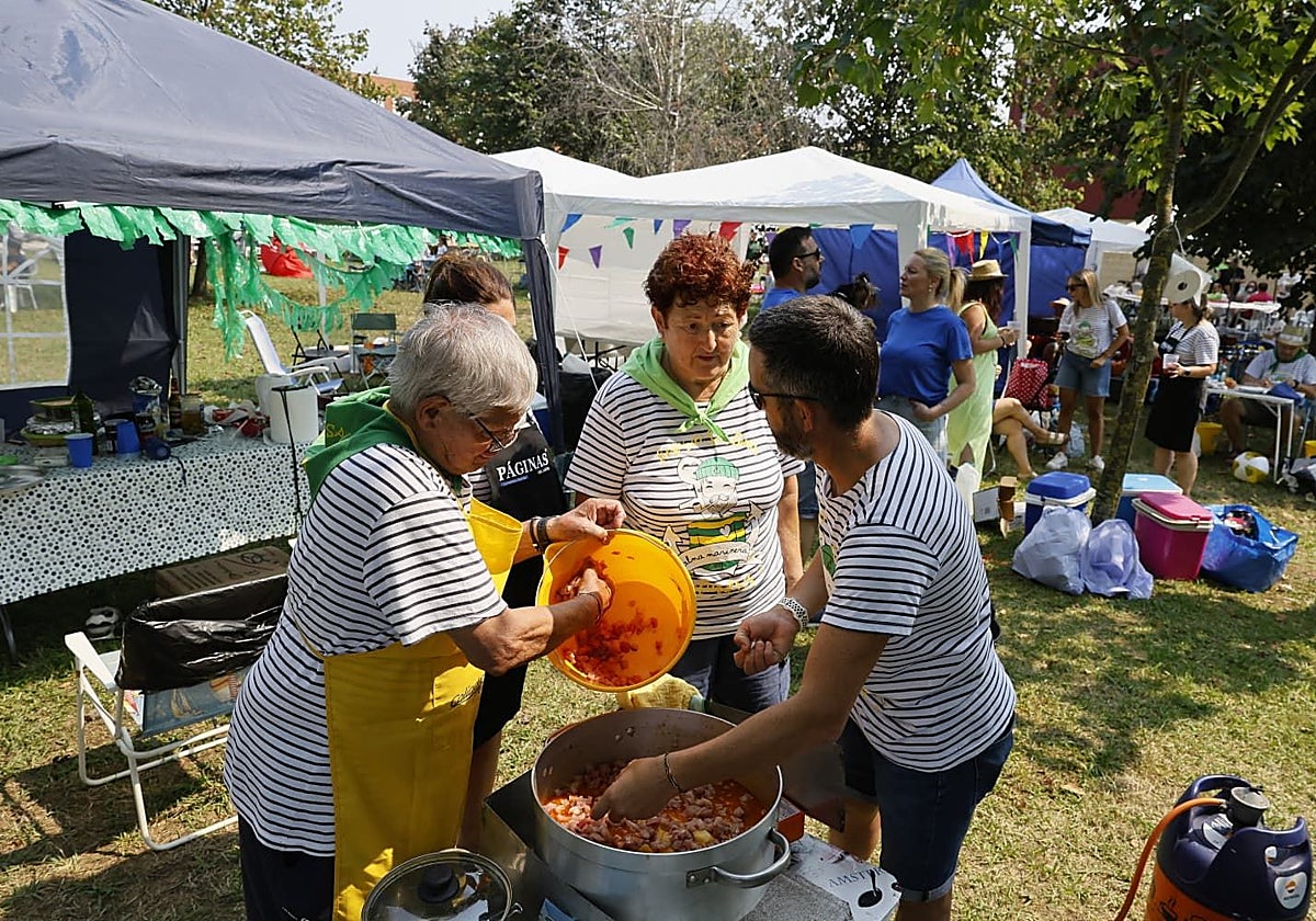 Cuadrilla de participantes durante la elaboración de su marmita en los puestos que se colocan junto al puerto de Colindres.
