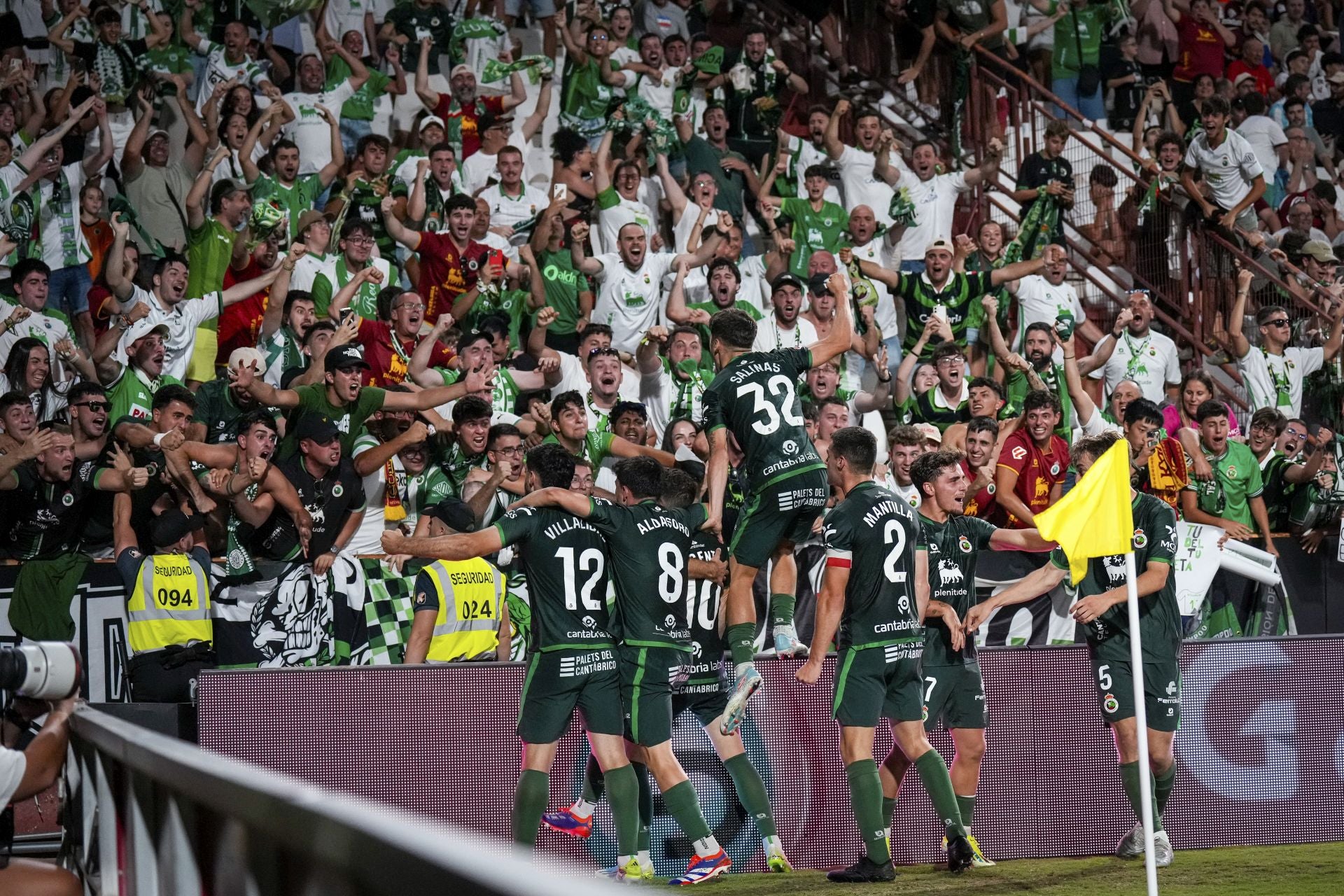 Los jugadores del Racing celebran con la afición desplazada el tercer tanto verdiblanco. 