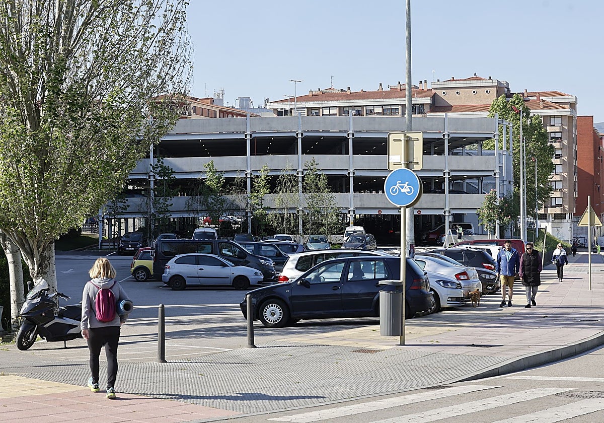 Vecinos caminan junto al aparcamiento de La Carmencita.