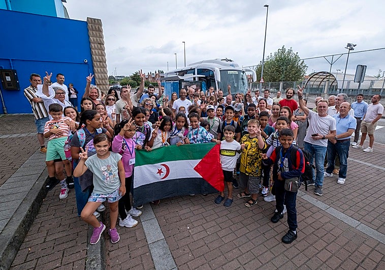 Los pequeños y las familias posando junto a la bandera de la República Árabe Saharaui Democrática.