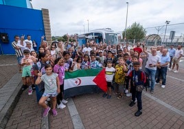 Los pequeños y las familias posando junto a la bandera de la República Árabe Saharaui Democrática.