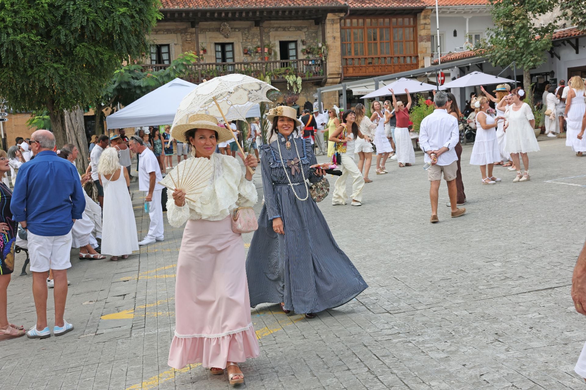 Los paraguas son una constante el Día del Indiano, en esta ocasión, para protegerse del sol.