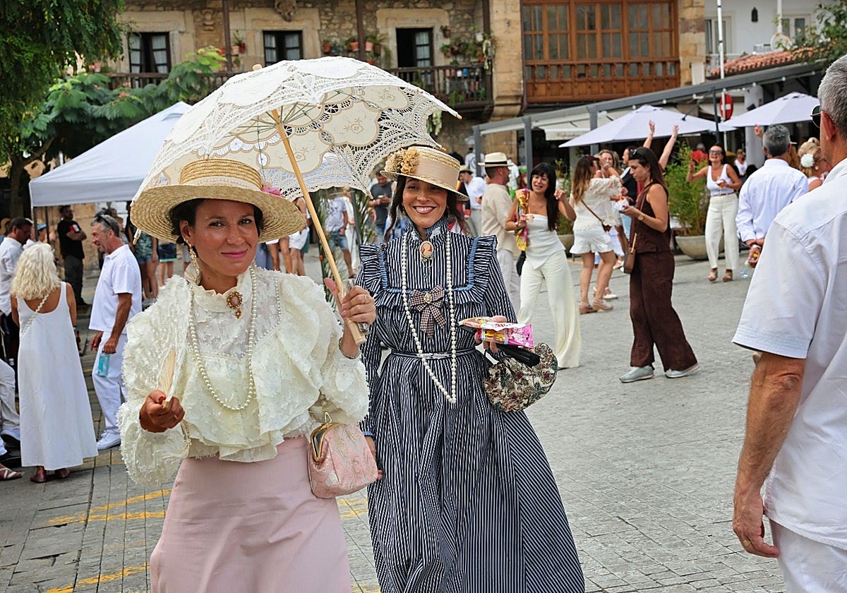 Dos mujeres vestidas de época en la plaza de la fuente Tres Caños de Comillas.