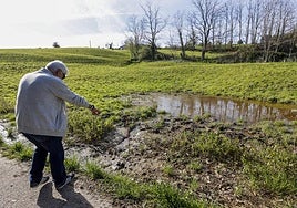 Un vecino del barrio, Bonifacio Sañudo, señala una zona que se inunda frecuentemente.