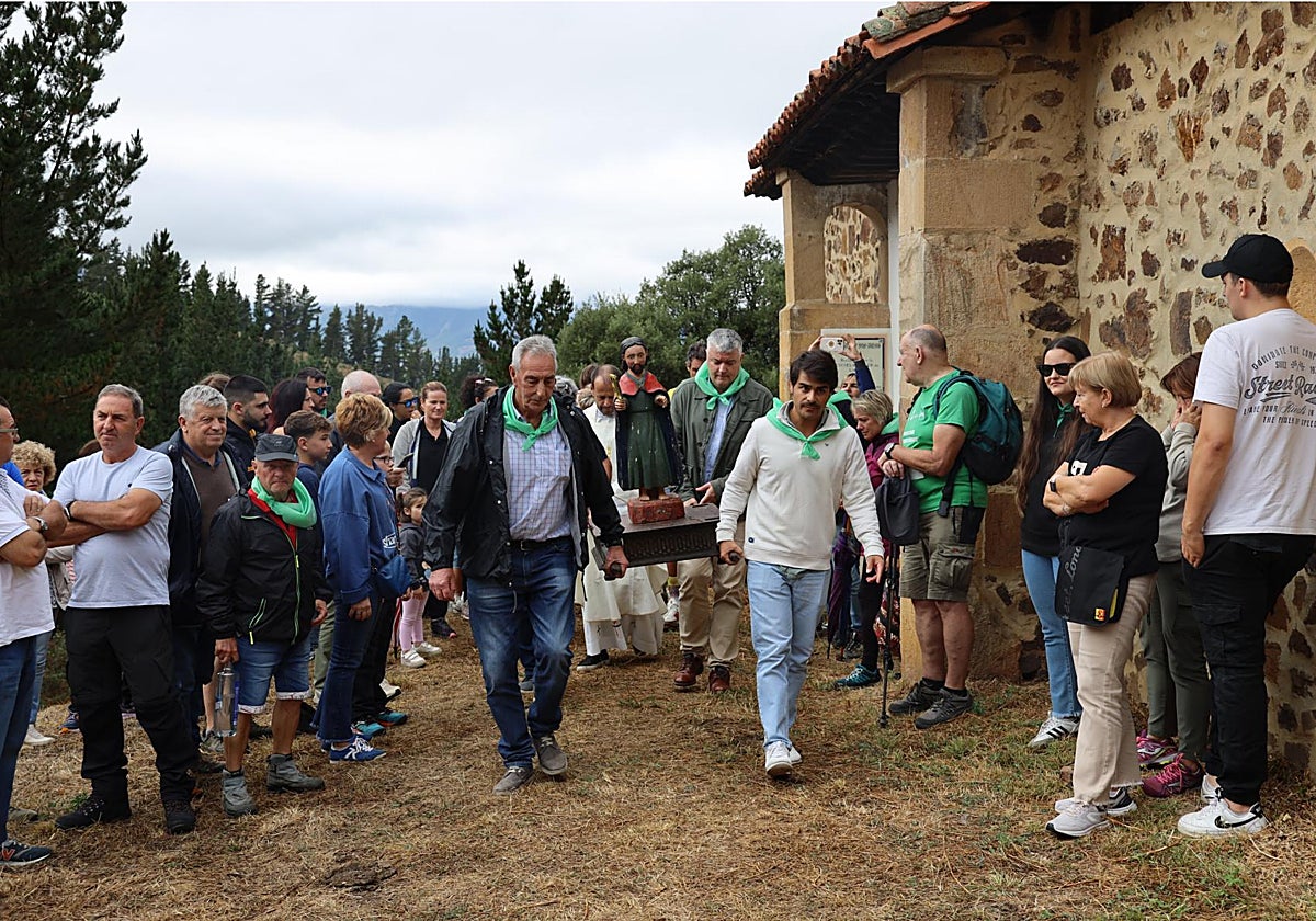 Los devotos y romeros llevan a la imagen de San Tirso en andas alrededor de la ermita