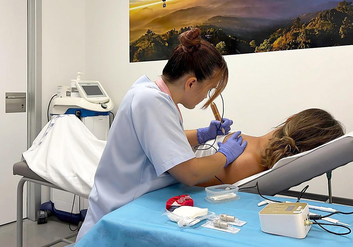 Una enfermera y una paciente durante la sesión de micropigmetación areolar.