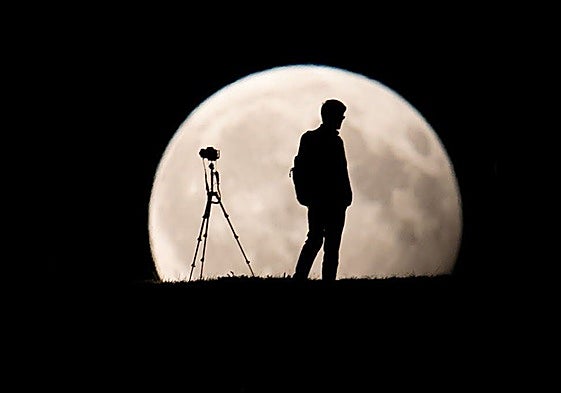 Una persona observa la Luna a través de un telescopio.