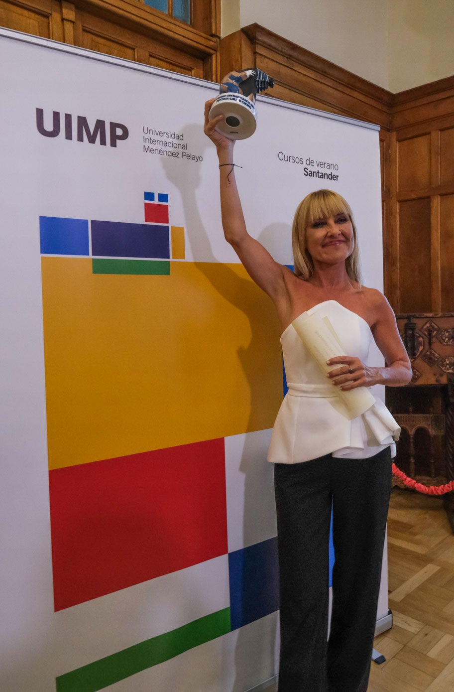 La actriz y comunicadora saluda con el premio en la mano.