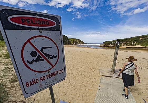 En la playa de Galizano un cartel indica la prohibición de bañarse por contaminación.
