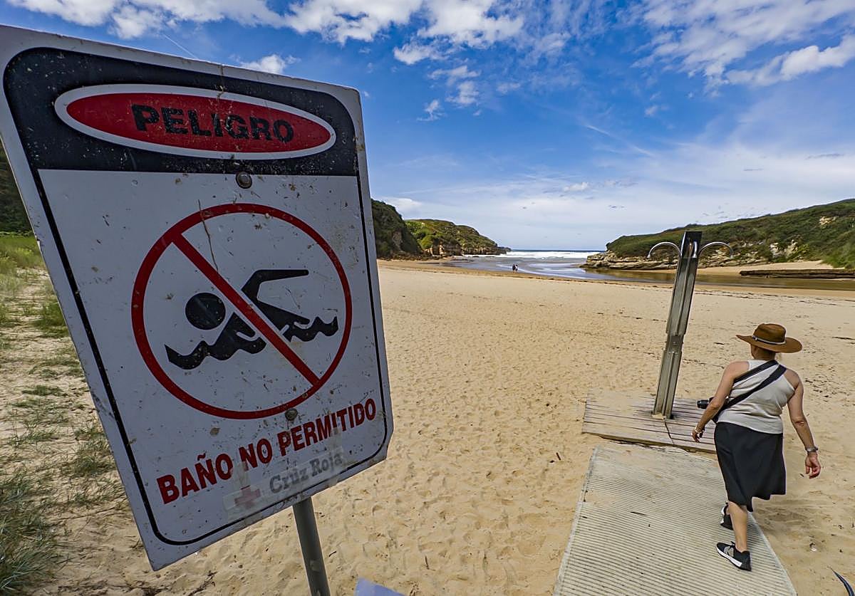 En la playa de Galizano un cartel indica la prohibición de bañarse por contaminación.