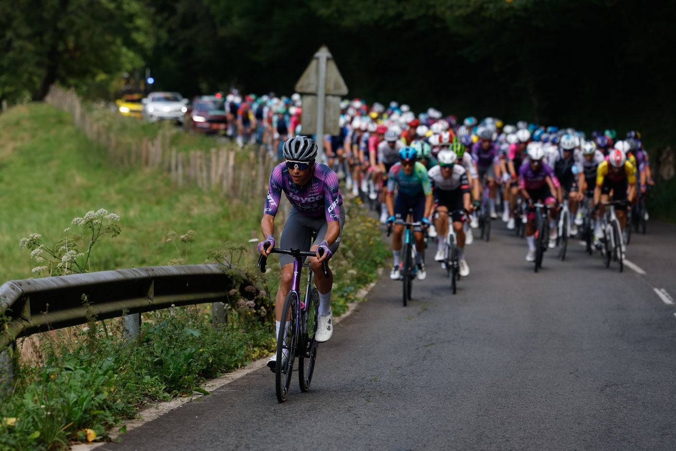 El pelotón, tras el grupo de escapados, llega al final del puerto de Alisas y emprede el camino hacia Liérganes.
