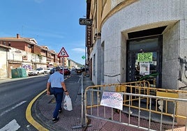Un vecino pasa junto al hostal La Torre, vallado por el riesgo de desprendimiento.