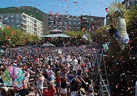 Multitud con el pañuelo marinero en alto cantando el himno de Santoña.